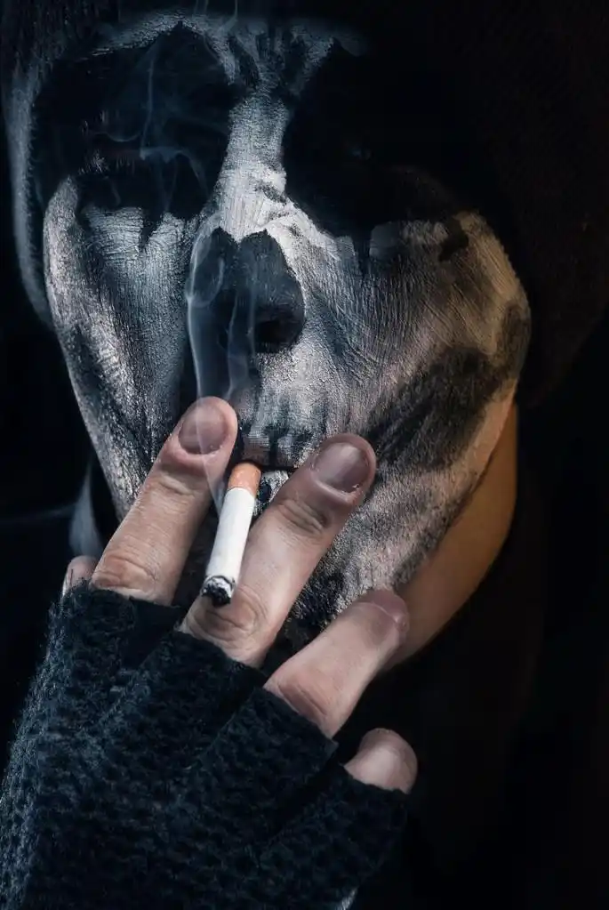 黑暗面具小丑,戴面具的家伙,他的脸画抽烟