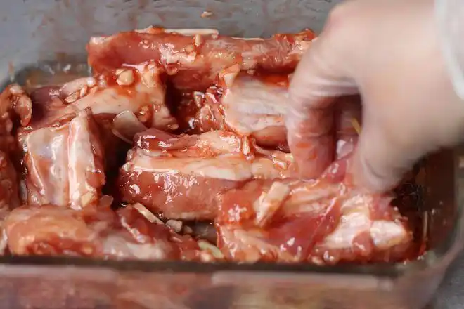 3,排骨有筋膜的部位用叉戳些洞,然后放入拌好的腌料,使每一块排骨都