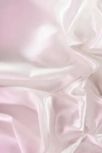 淡粉红色皱起光泽丝绸面料背景