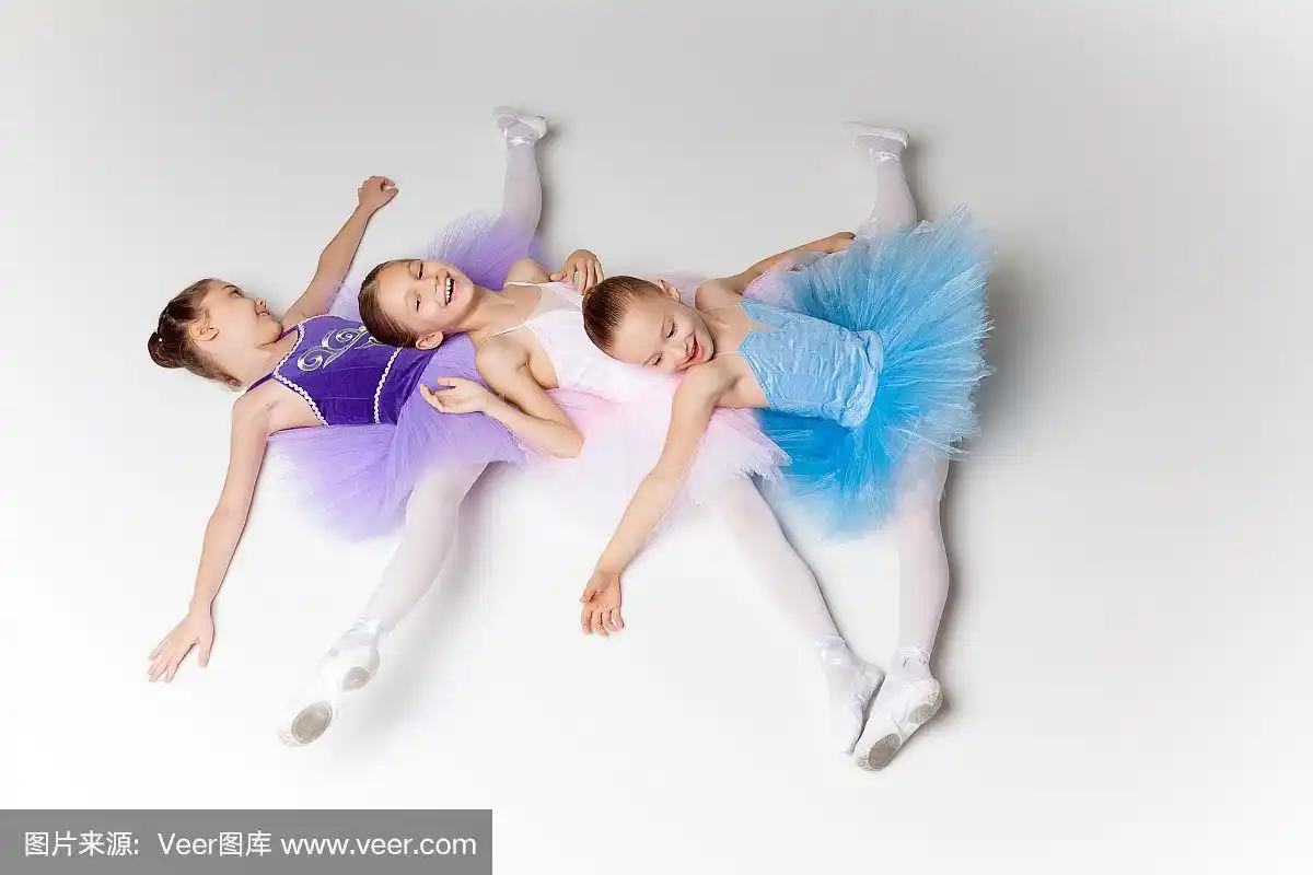 三个芭蕾舞小女孩穿着芭蕾舞裙躺在一起摆姿势