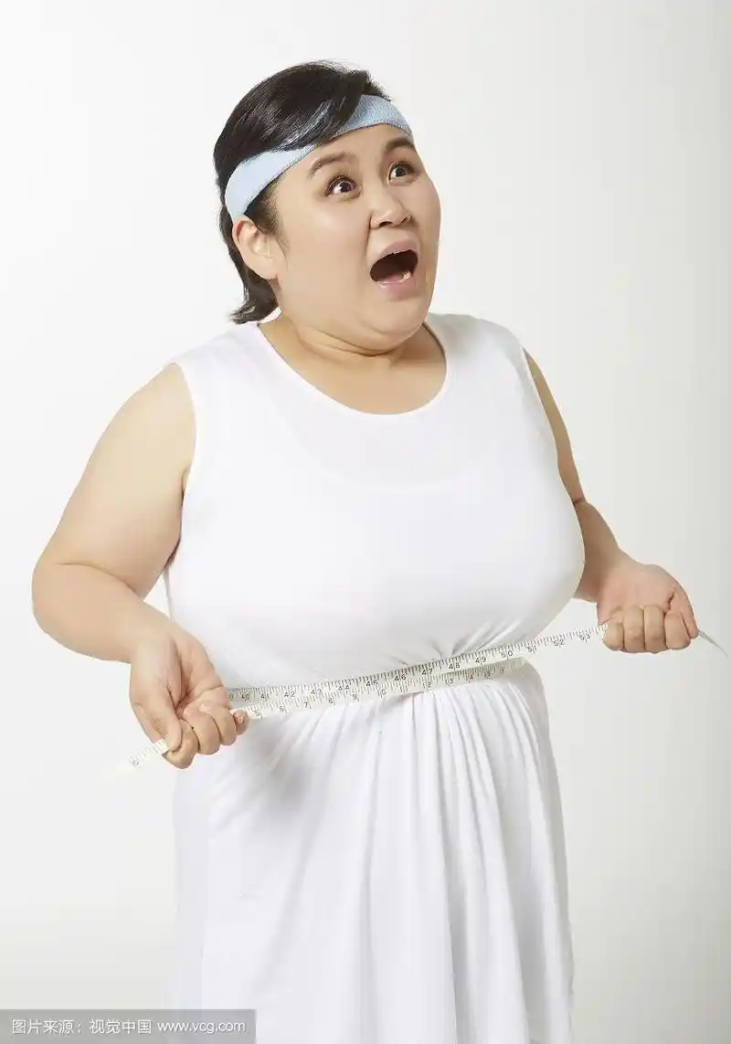 穿着运动服的胖女人在量她的腰围