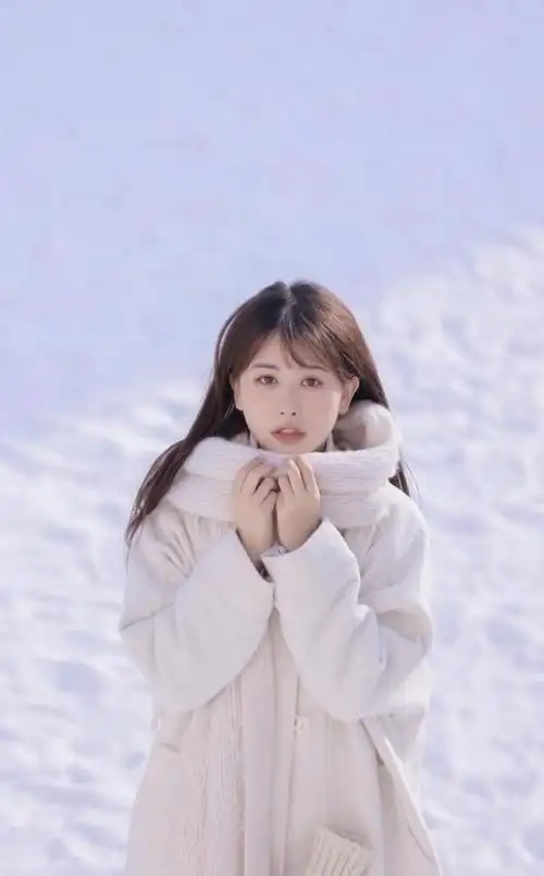 冬装也可以很漂亮雪景中的女孩穿白色呢子大衣搭配围巾好清纯