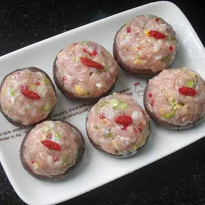 5.肉末捏成肉丸子放入香菇中,捏紧,摆在盘中,放上洗净的枸杞