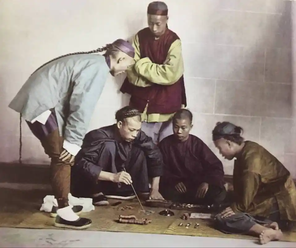 清朝末年赌博盛行,在街头经常有人在赌博,可以看到图片上有赌注,就是