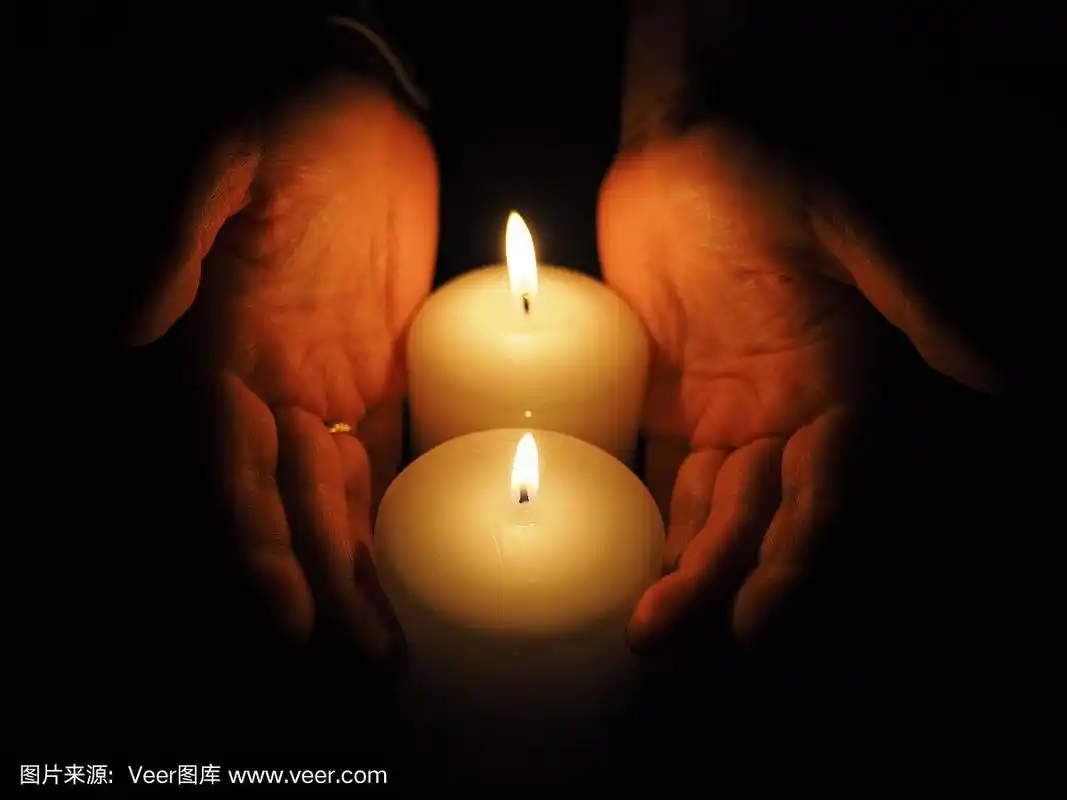 蜡烛和手放在黑色背景上