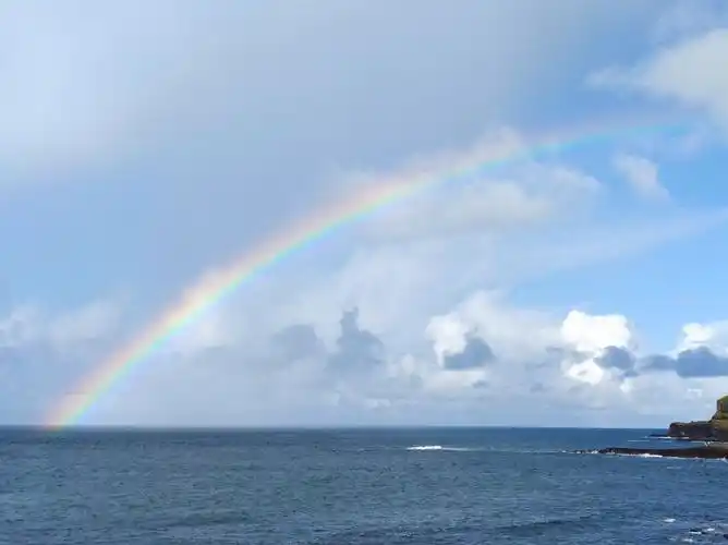 海面上升起了巨大的彩虹,使游客们大饱眼福.