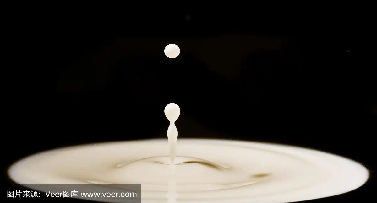 牛奶滴-牛奶滴落在白色液体上,并产生圆形波纹.乳制品孤立在黑色背景