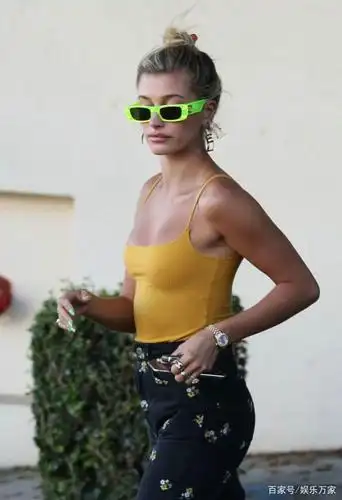 海莉戴个性墨镜潮范十足,黄色吊带背心搭黑裤尽显街头休闲风