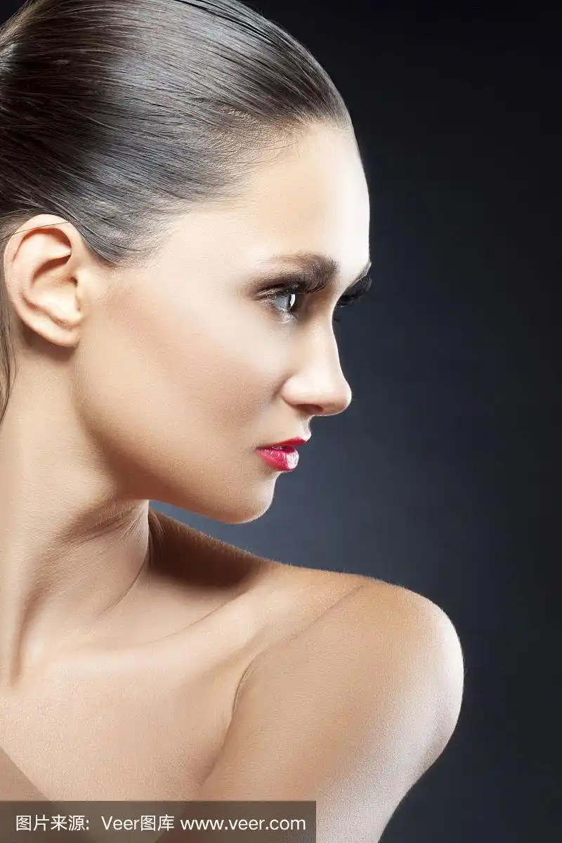 女孩美丽的侧面,干净的皮肤,红润的嘴唇.黑色背景