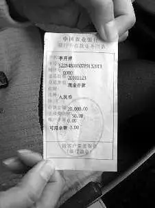 郭女士拿着2万元的汇款单无可奈何.