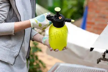 女园丁拿着喷洒农药的喷雾器