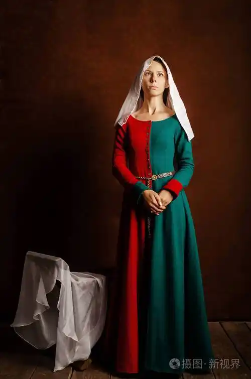 一个美丽的女孩的肖像,穿着一件中世纪的衣服,红色和绿色,棕色背景.