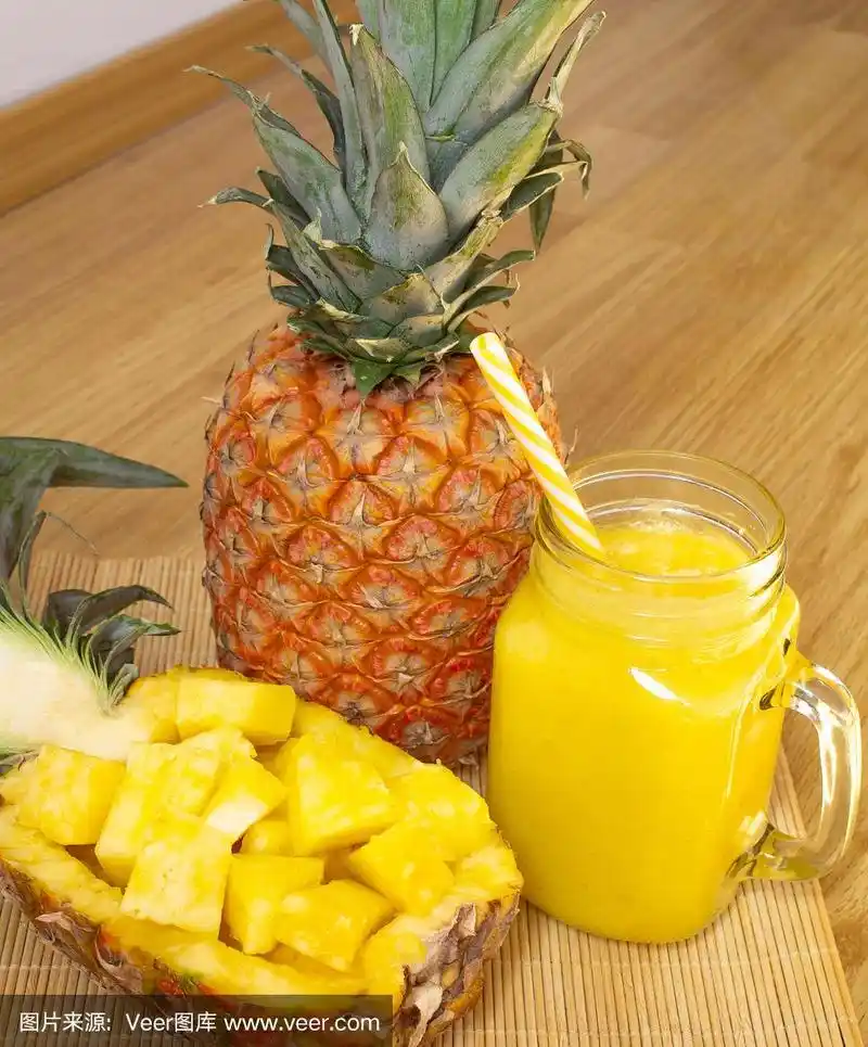 菠萝汁,新鲜的菠萝冰沙作为早餐放在木桌上.排毒.为了健康和减肥.