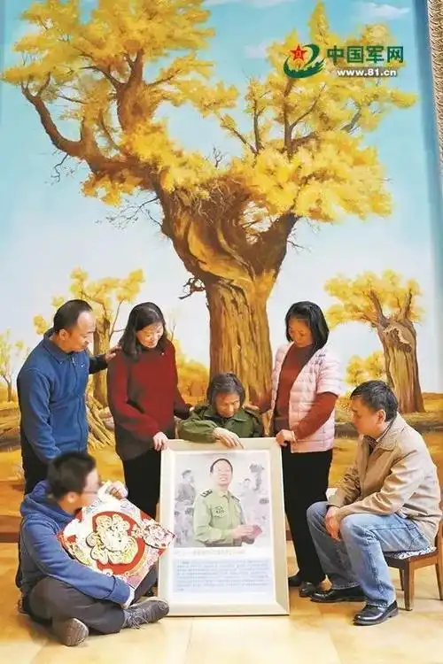 林俊德夫人黄建琴抱着林俊德的英模挂像,和儿子,儿媳,女儿,女婿,孙子