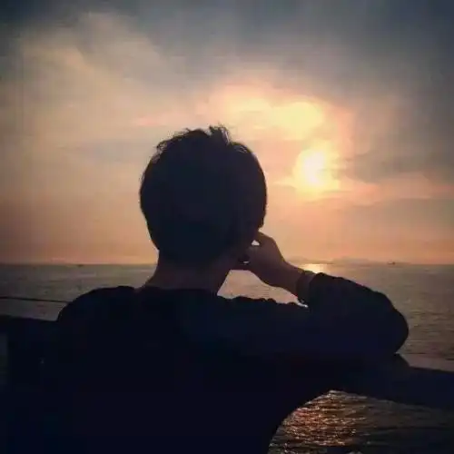 一个男的坐在红椅子上,背影,面对海边头像