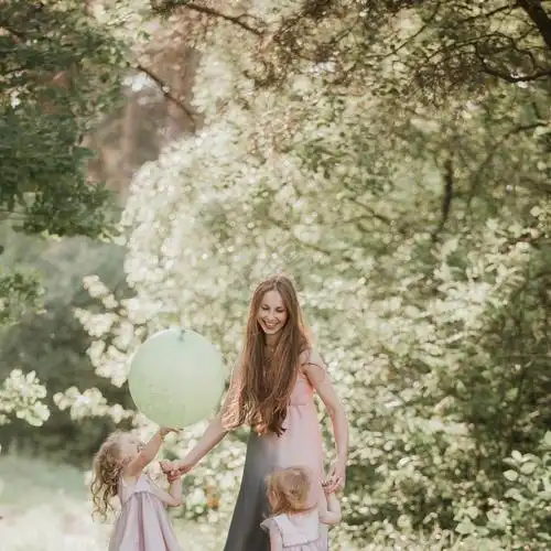 母亲和两个女儿在公园里玩得开心幸福的家庭观念美丽的自然景观与家庭