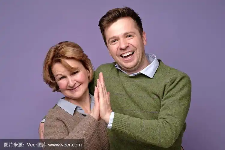 成熟的女人和年轻的男人母亲和儿子互相击掌