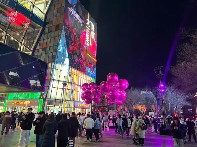 晚上9点,三里屯商圈里的时尚装置前挤满了前来打卡的游客,一串串巨大