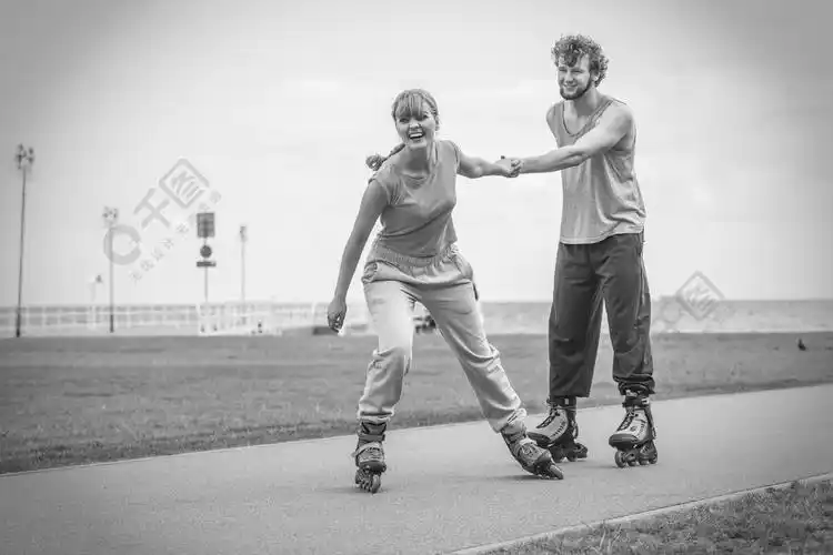 爱浪漫运动健身休闲理念青少年夫妇一起在溜冰鞋上女孩和男孩在沿海