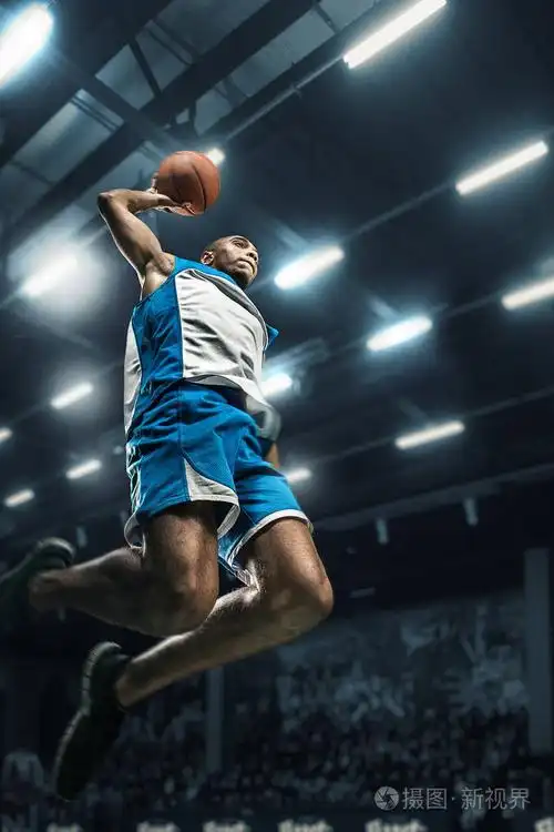篮球运动员在大的专业竞技场比赛期间.篮球运动员打扣篮