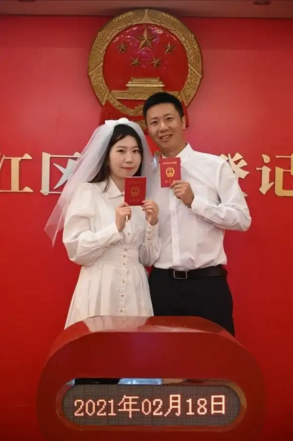 新人任先生和李女士手持结婚证甜蜜合影