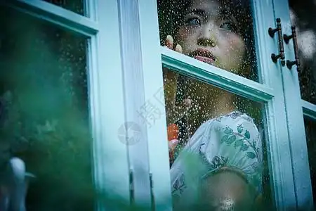 下雨天靠在窗边发呆的女性图片素材