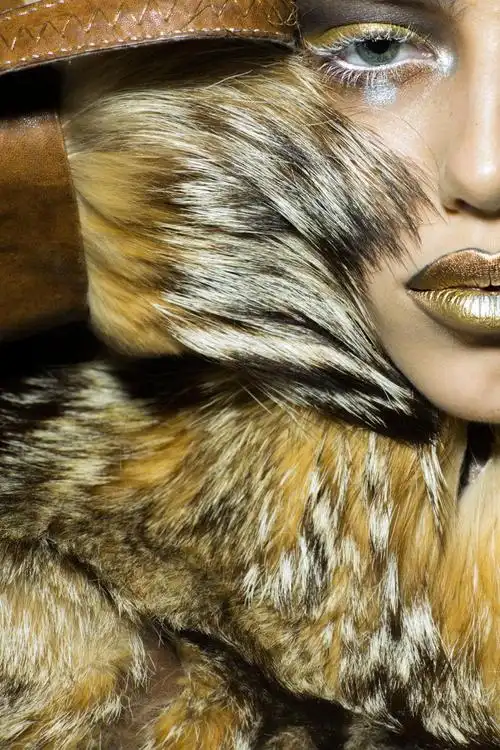 脸上有刺的美丽的野生年轻女子有着金色的动物猴妆