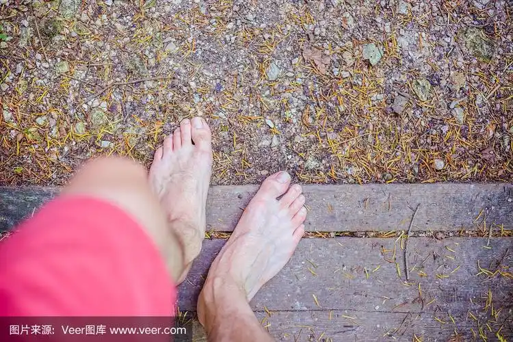 森林探险:赤裸着脚的男性脚在森林中的木桥上的特写