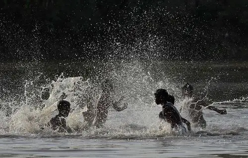 4月19日,在巴基斯坦拉合尔,少年在河中戏水降温.
