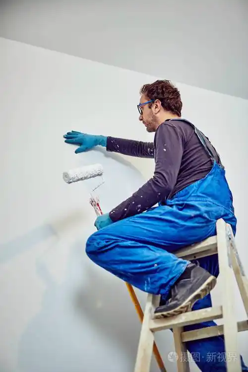 工人粉刷房屋内的墙壁装修修复