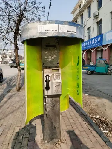 在泰安市宁阳县乡饮乡街头一个废弃的旧电话亭引起了小朋友的好奇