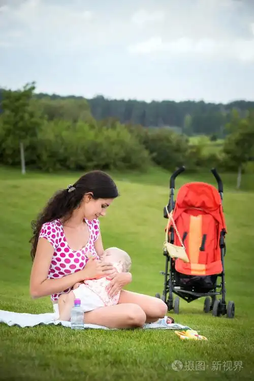女子母乳喂养她的孩子户外活动