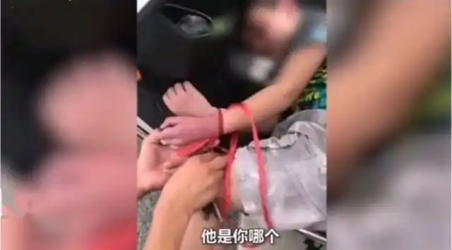 亲妈!马路上四川女子把孩子捆绑手脚横放在车前,手被勒成紫色