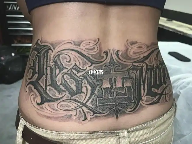 后腰中间位置有个小花纹身现在用字体的设计遮盖掉 "less is more"