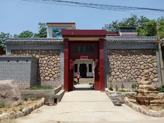 民居门外,河卵石砌成的院墙,用青砖灰瓦框起来,现代的古朴.