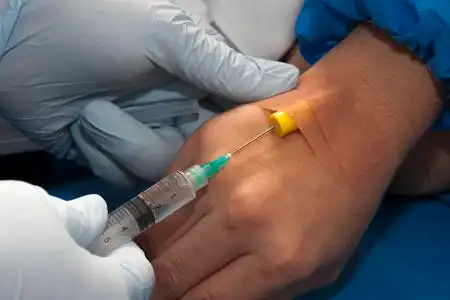 护士给病人打针护士在手臂病人验血的刺针注射器美丽年轻的医生或护士