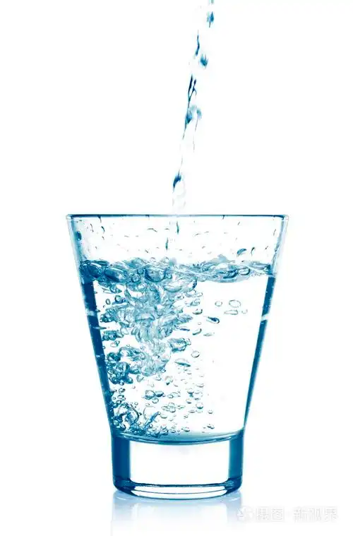 清澈的水被倒在白色背景上孤立玻璃杯子