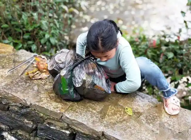 阿者科村里正在捡垃圾的小朋友