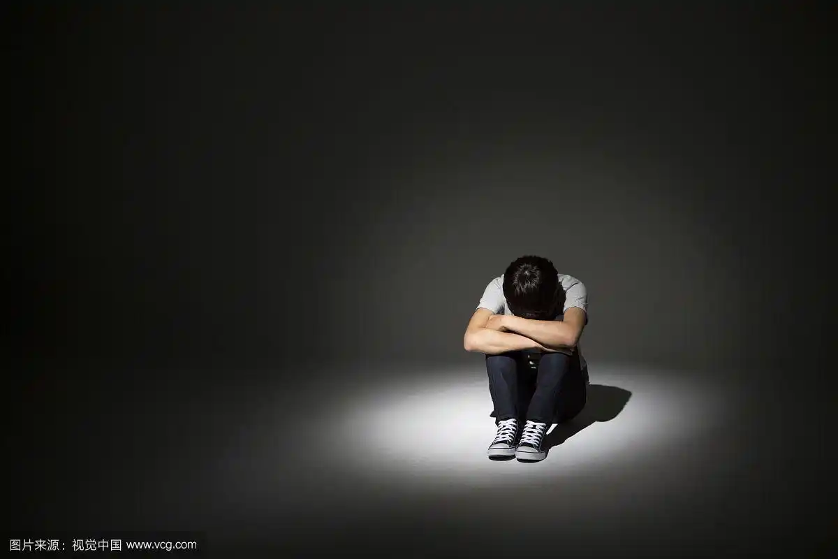 一个学校男孩独自在黑暗中的照片