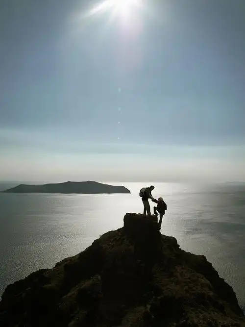 登山者攀登山顶的剪影图片下载