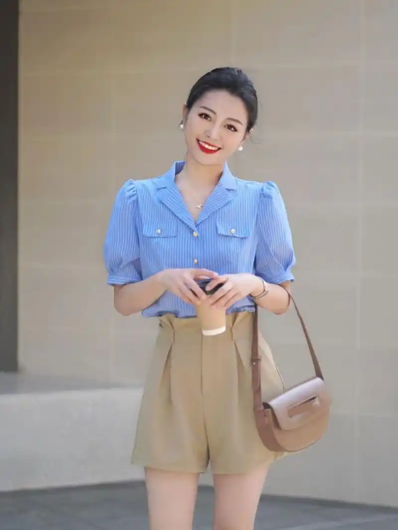 一件泡泡袖的蓝色衬衫搭配上卡其色的西装短裤,这样的穿搭简约干练,很