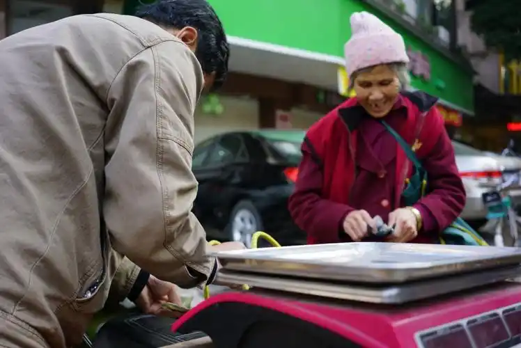 老太婆刚成交了买卖,收钱了,你看她那开心的眼神