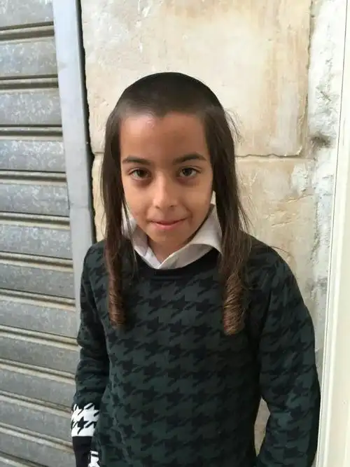 一个小犹太教徒,他两边似小辫子的鬓发是"联通上帝的渠道".