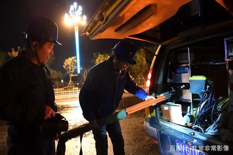 纪实摄影《夜幕下的光明使者》,记录电力工人夜晚坚守岗位送光明