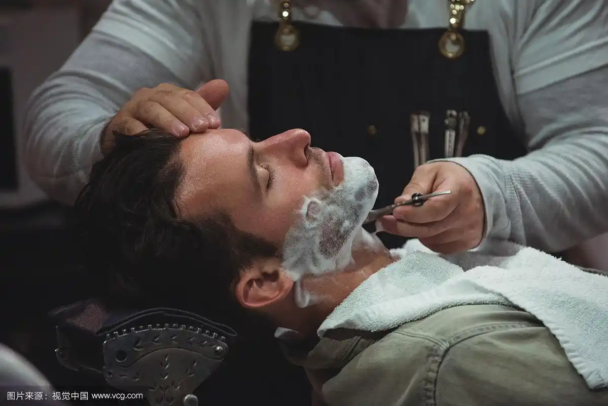 用剃刀刮胡子的男人