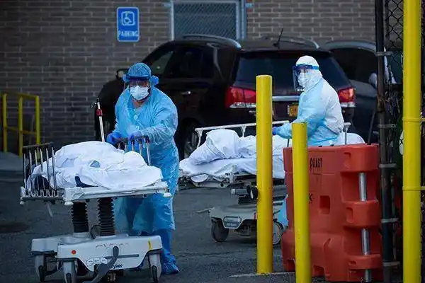 4月6日,在美国纽约,医护人员将死亡患者遗体推出医院,送往临时冷藏车.