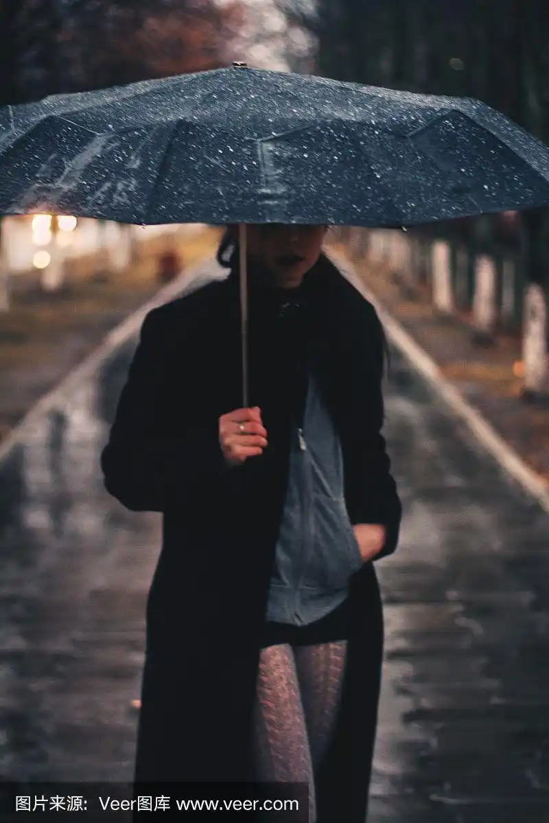 孤独的女人撑着伞站在雨中