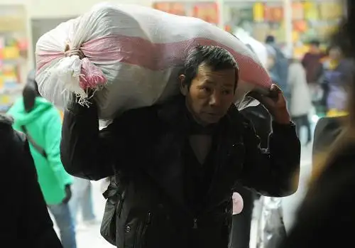 1月26日,一名背着大包的农民工在郑州火车