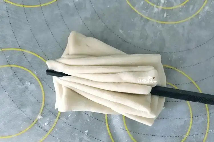 5,再来找一根筷子,顺着面片的尖角的直线用力压下去再把筷子抽出.