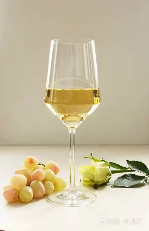 一杯白葡萄酒一束白葡萄白玫瑰在桌上